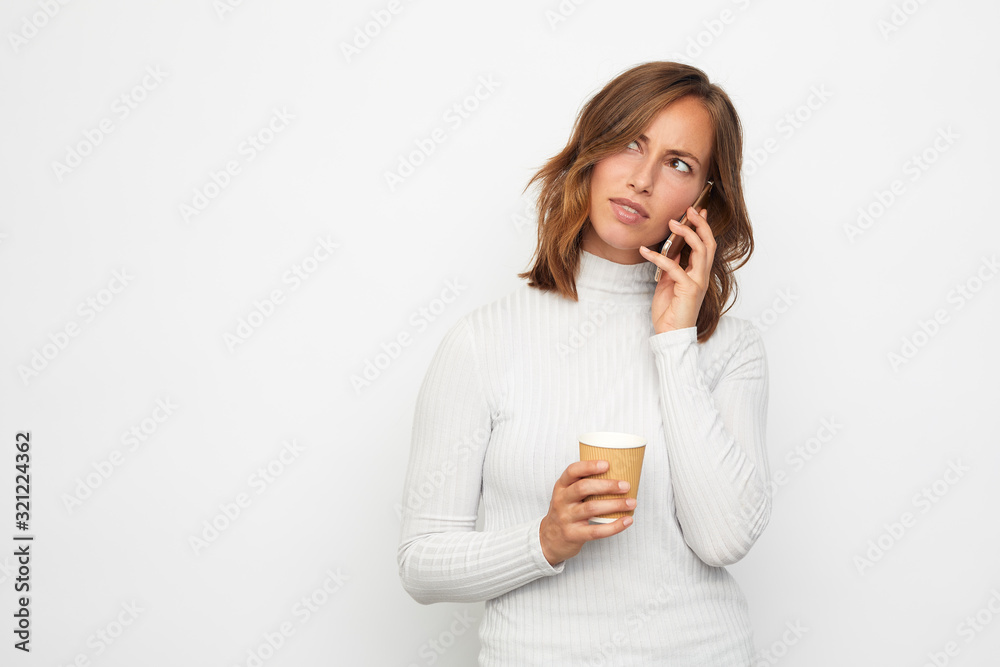 young woman with a cup of coffee, having a frustrating conversation young woman with a cup of coffee, having a frustrating conversation