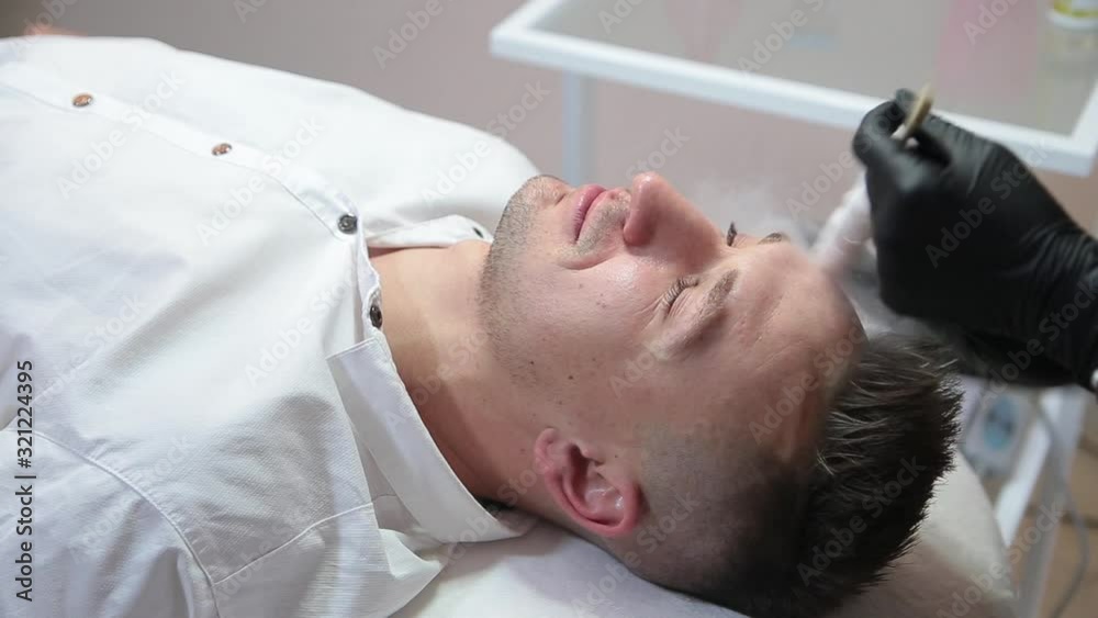 Therapy with liquid nitrogen for the face of a man. Therapy with liquid nitrogen for the face of a man.