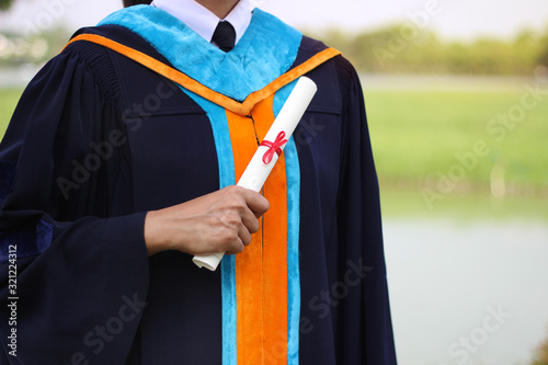 A successful female graduate receives a certificate. She looks confident.