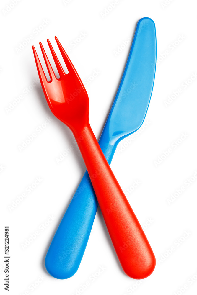 Crossed plastic red fork and blue knife, isolated on white background Crossed plastic red fork and blue knife, isolated on white background
