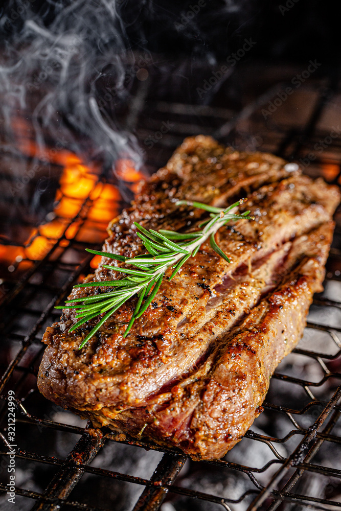 American cuisine. The process of hot smoking boiled pork on the grill. The meat is on fire. background image, copy space text American cuisine. The process of hot smoking boiled pork on the grill. The meat is on fire. background image, copy space text