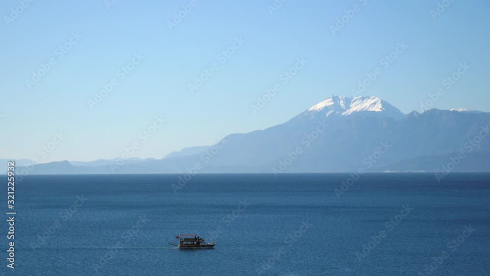 Small Turkish fishing boat crossing a section of the calm Mediterranean Sea in Antalya, Turkey Small Turkish fishing boat crossing a section of the calm Mediterranean Sea in Antalya, Turkey