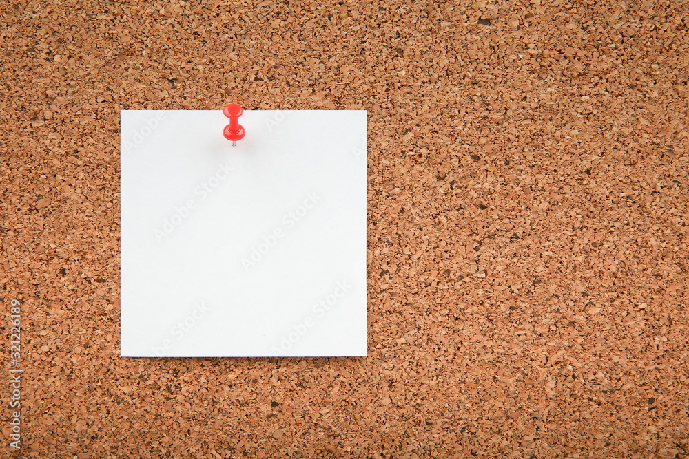 One blank note paper on cork board with copy space. Blank note paper pinned to corkboard One blank note paper on cork board with copy space. Blank note paper pinned to corkboard