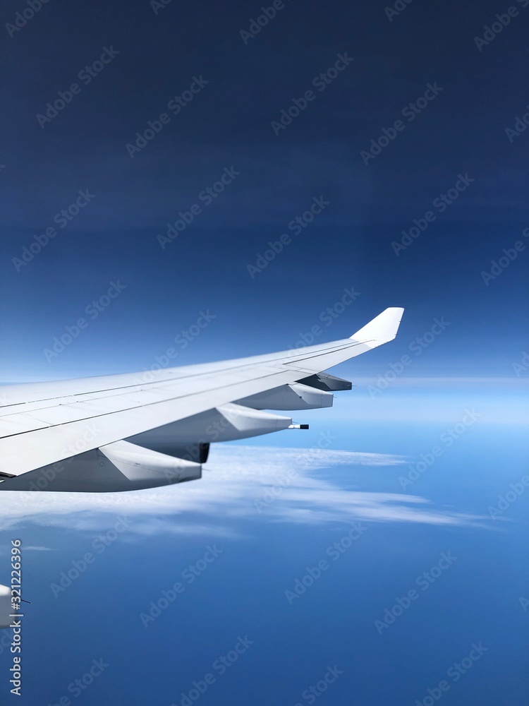wing of an airplane flying above the clouds wing of an airplane flying above the clouds
