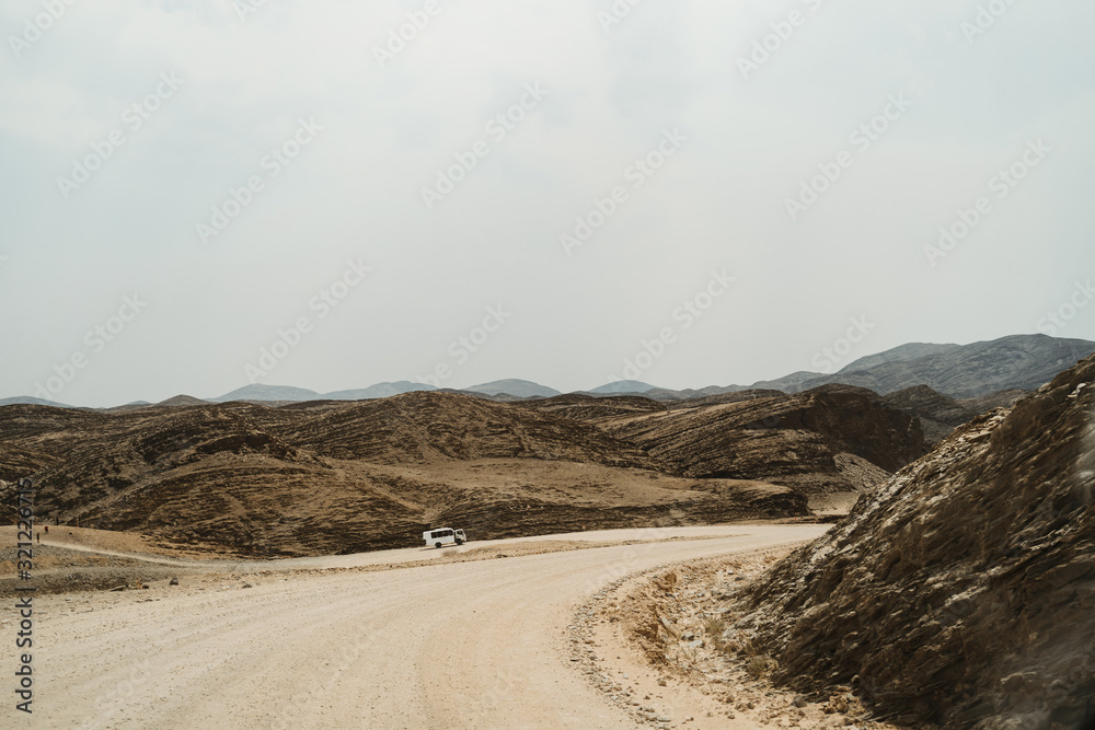 Fototapeta premium lonely road throug dead moon Landscape with rocks, stones and mountains
