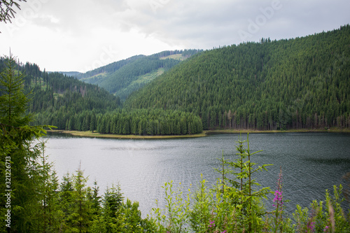 un frumos lac de munte, inconjurat de o mare padure de conifere. Un frumos peisaj de munte. photo