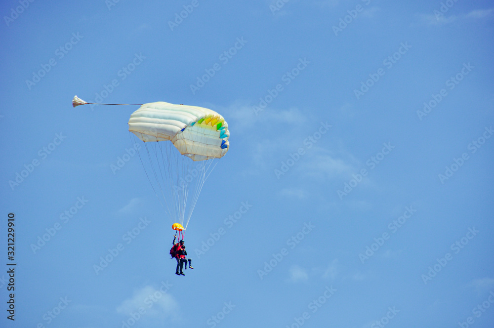 Tandem skydiving, shot of two parachutists about to land at Gap Tallard, France after a jump on a beautiful day Tandem skydiving, shot of two parachutists about to land at Gap Tallard, France after a jump on a beautiful day