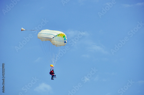 Tandem skydiving, shot of two parachutists about to land at Gap Tallard, France after a jump on a beautiful day