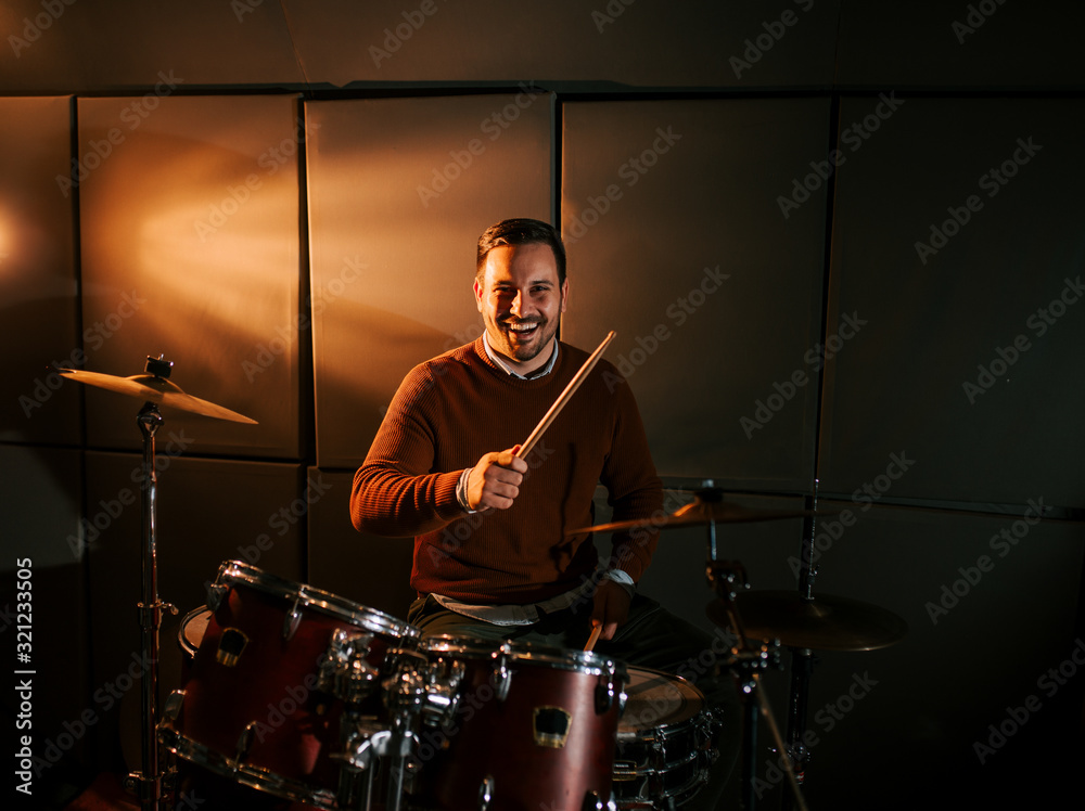 Portrait of a happy drummer playing drums and smiling at camera. Portrait of a happy drummer playing drums and smiling at camera.