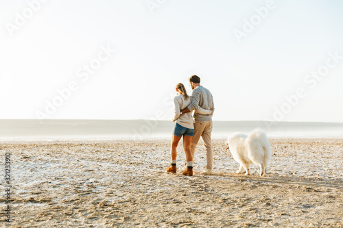 Cheerful young couple walking at the beach