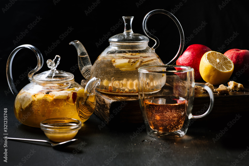 Glass teapots with fruit tea in composition on black background Glass teapots with fruit tea in composition on black background