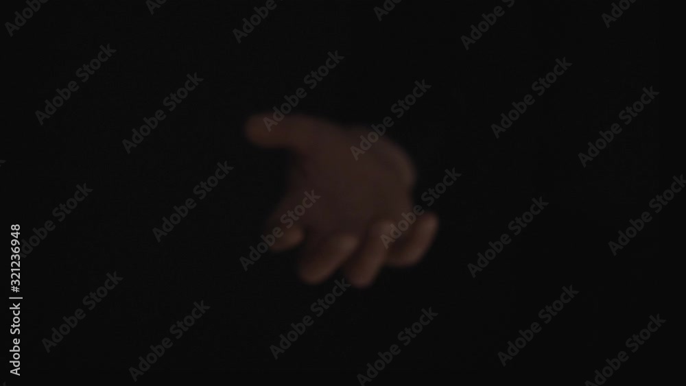 A hand on a black background invites you to enter. Climate lighting. Recorded in 4K 60fps. High-quality recording in a professional film studio. A hand on a black background invites you to enter. Climate lighting. Recorded in 4K 60fps. High-quality recording in a professional film studio.
