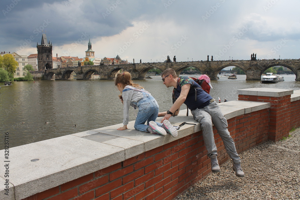 man and child look at the river near Charles bridge, Prague - obrazy, fototapety, plakaty 