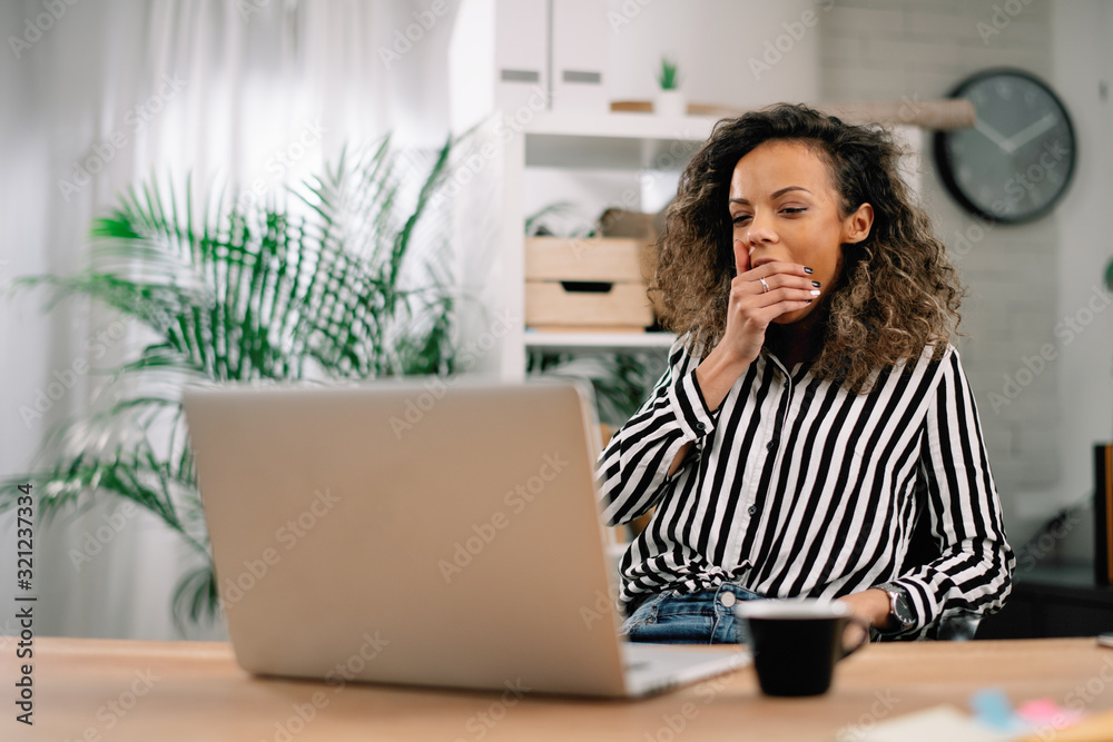 Sleepy businesswoman in office. African woman overworked. 