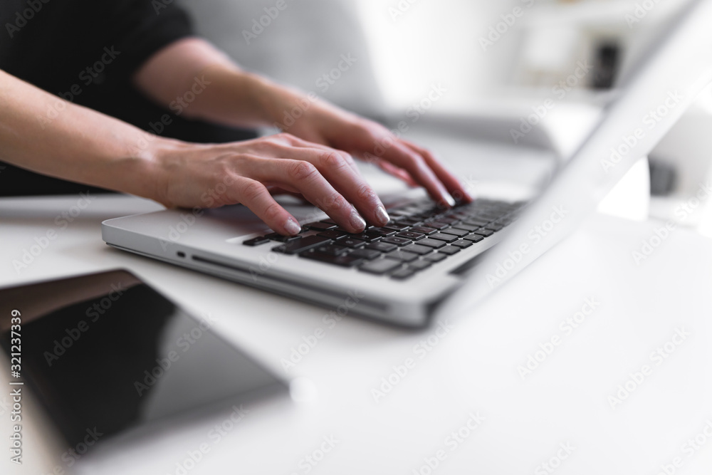 Person using laptop and typing on a keyboard.