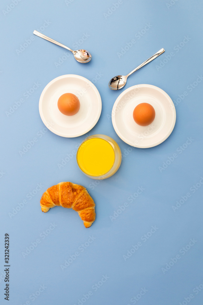 Fun breakfast concept with abstract angry, grumpy human face made of breakfast items on blue background. Fun breakfast concept with abstract angry, grumpy human face made of breakfast items on blue background.