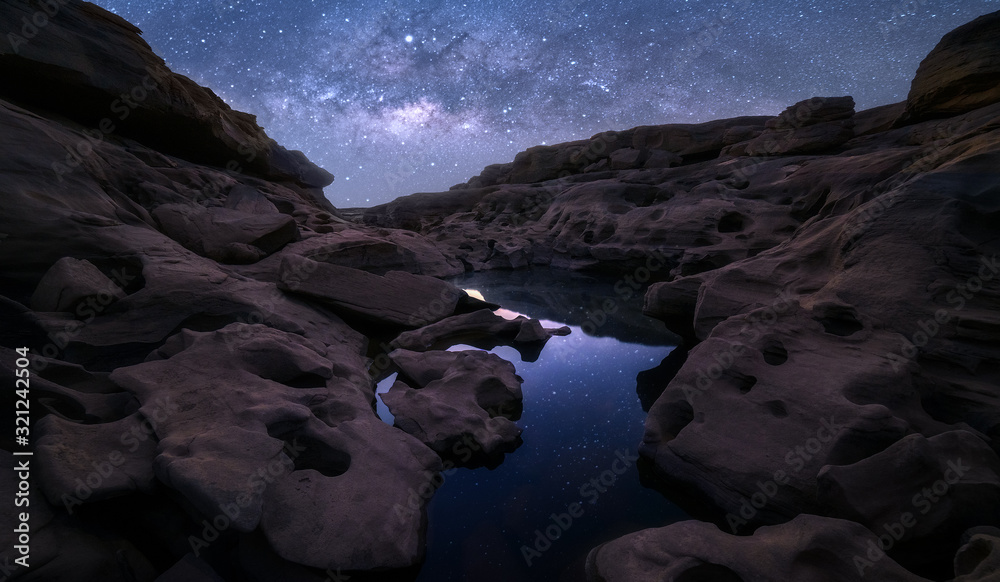 Fototapeta High rock cliffs with the Milky Way galaxy and reflections