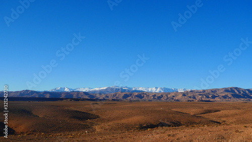 Fototapeta Naklejka Na Ścianę i Meble -  Bright landscape of Morocco, breathtaking curves of mountains, stunning combination of hills & farm land,inadvertent distribution of houses & huts, raw impression of pure nature.