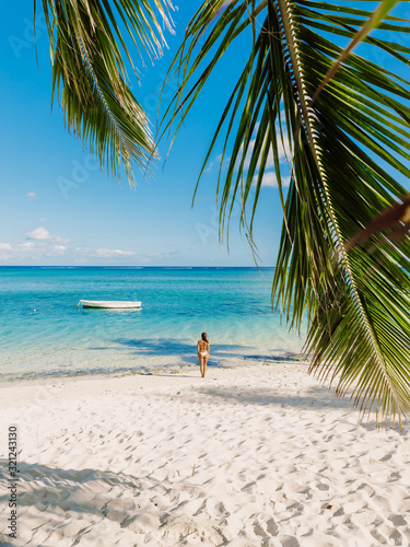 Fototapeta Naklejka Na Ścianę i Meble -  Young woman in bikini relax at tropical palm beach. Tropical vacation