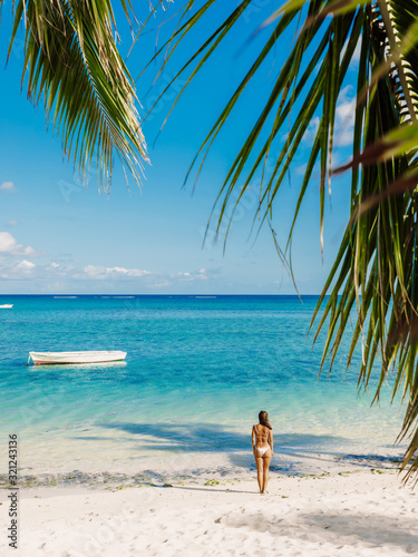 Young woman in bikini relax at tropical palm beach. Tropical vacation © artifirsov