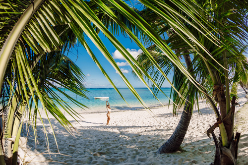 Young woman in bikini relax at tropical palm beach. Tropical vacation