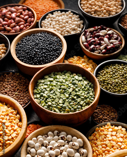 Legumes, a set consisting of different types of beans, lentils and peas on a black background, close up. The concept of healthy and nutritious food