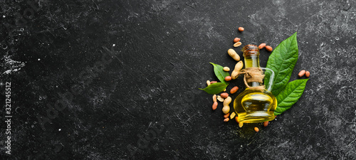Peanut oil is cold pressed. Peanuts on a black stone background. Top view