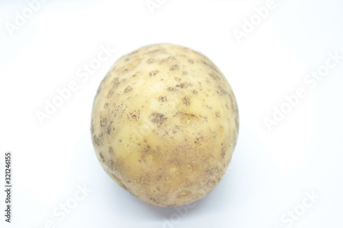 Potato tuber perched on a white background