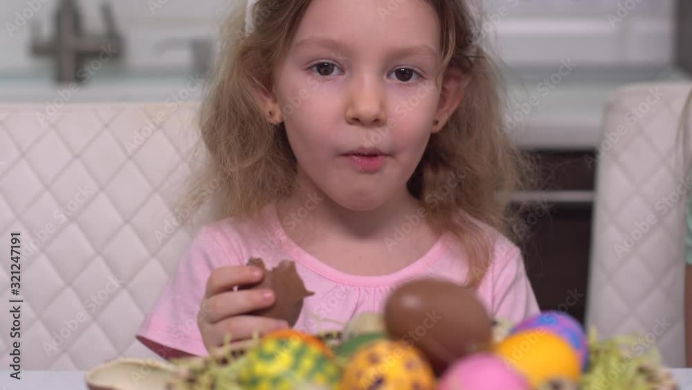 Happy easter. Chocolate egg. A little girl in rabbit ears shows up from behind Easter eggs. Happy family children preparing for Easter. Cute little child girl wearing bunny ears on Easter day. Happy easter. Chocolate egg. A little girl in rabbit ears shows up from behind Easter eggs. Happy family children preparing for Easter. Cute little child girl wearing bunny ears on Easter day.