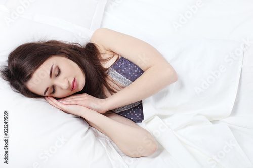 Young beautiful woman sleeping in her bed and relaxing in the morning.