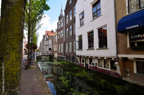 Delft, the netherlands, august 2019. The pretty and romantic canals, smaller than in Amsterdam. The aquatic plants create a green carpet.