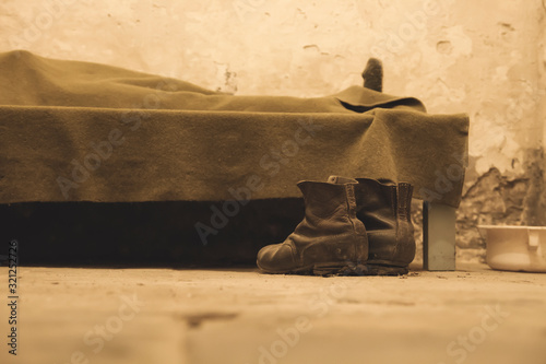 a pair of boots beside a bed photo