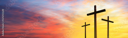 Cross of Jesus Christ empty over dramatic sunrise sky panorama with sclouds. Easter concept