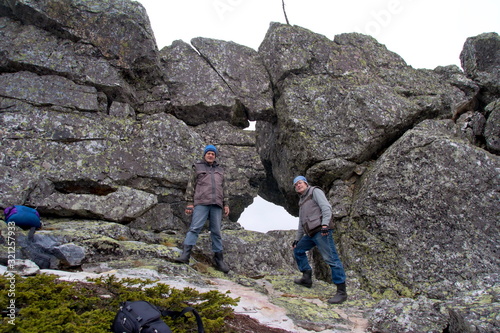 Southern Urals. Mature tourists make the ascent to the top along a large stone placer. photo