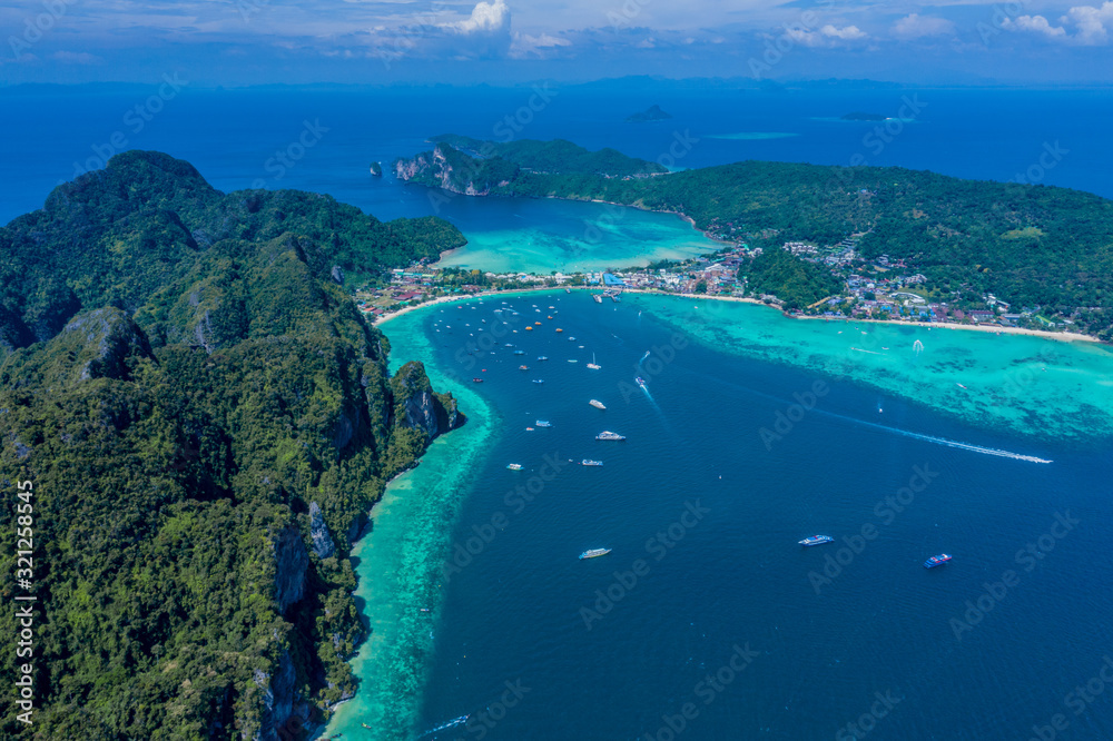 Aerial view of Phi Phi, Maya beach with blue turquoise seawater, mountain hills, and tropical green forest trees at sunset with Andaman sea  island in summer, Thailand in travel trip. Nature. Panorama