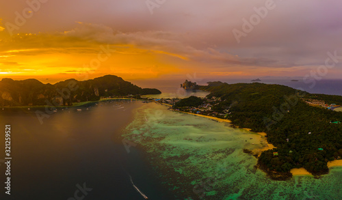 Aerial view of Phi Phi, Maya beach with blue turquoise seawater, mountain hills, and tropical green forest trees at sunset with Andaman sea island in summer, Thailand in travel trip. Nature. Panorama