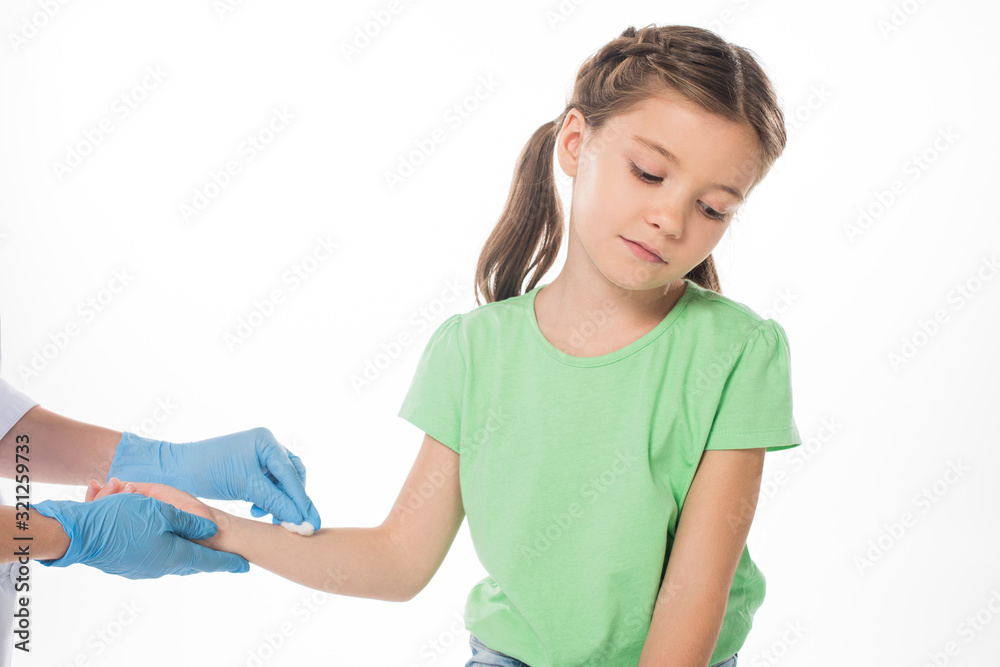 Pediatrician with cotton wool rubbing hand of kid isolated on white Pediatrician with cotton wool rubbing hand of kid isolated on white