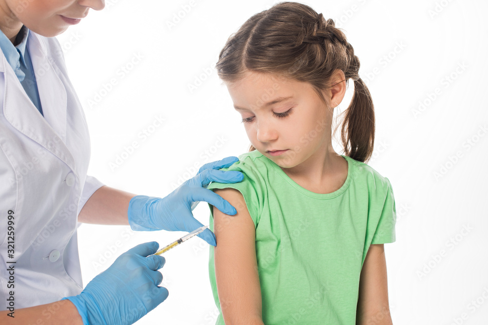 Female pediatrician doing vaccine injection to child isolated on white Female pediatrician doing vaccine injection to child isolated on white