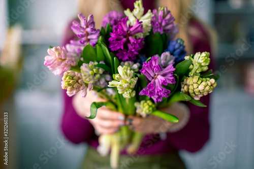 Female florist creating beautiful bouquet in flower shop  close up