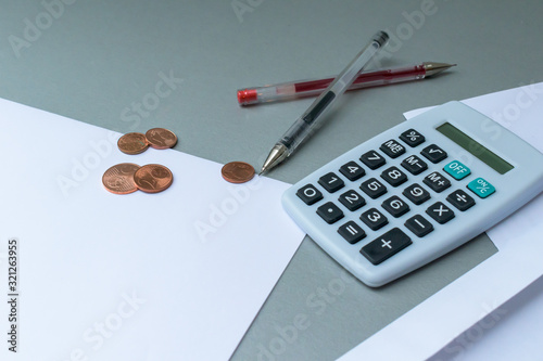 Empty letter and envelope with a calculator and pens and euro coins on a modern blue background