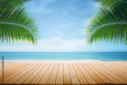 Summer ocean beautiful blurred background Palm leaves in the foreground And parquet plank flooring Abstract style backdrop © photosky99