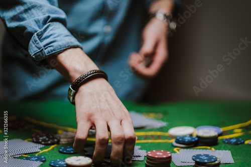 The croupier holds playing cards, game chips on the table. poker concept