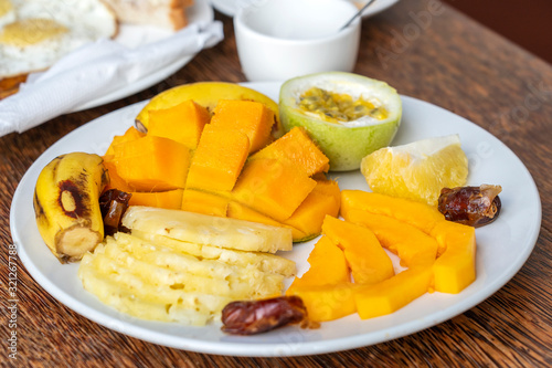 Fototapeta Naklejka Na Ścianę i Meble -  Tropical fruits on a breakfast plate, close up