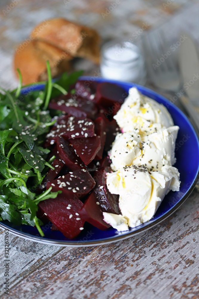 Selective focus. Delicious salad with beets, arugula and mascarpone cheese. Keto salad. Keto diet.