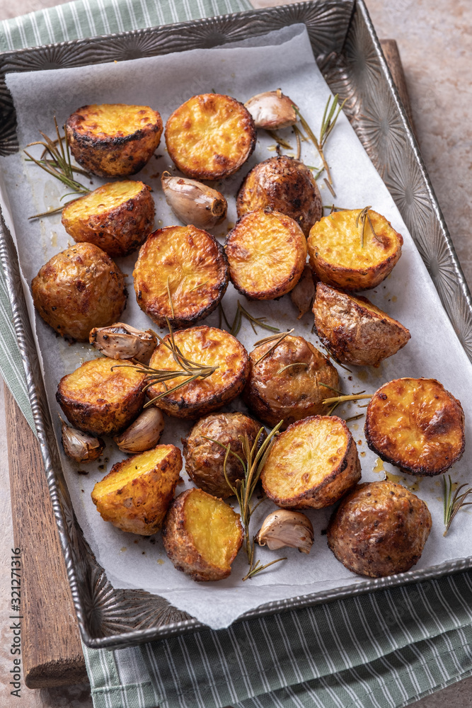 Roasted potato with rosemary on a baking sheet Roasted potato with rosemary on a baking sheet