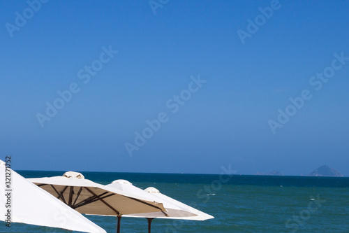  white umbrellas on the beach against the sea