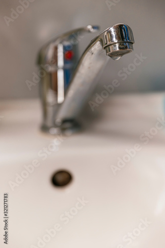 Water drop on the tap at the sink.