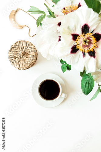 Coffee cup and white peonies flowers bouquet on white background. Flat lay, top view floral composition.