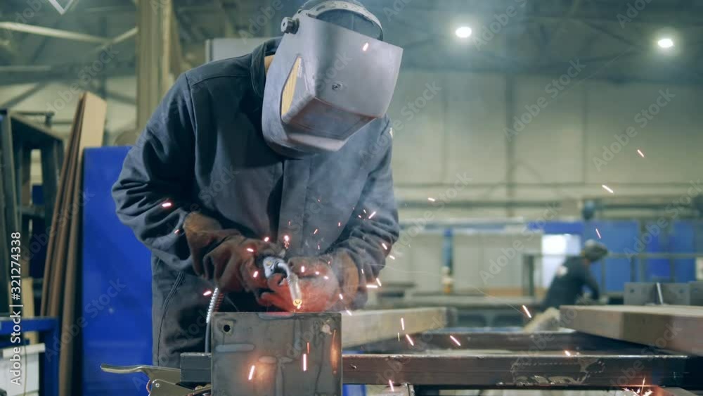Professional Welder Working at factory facility. Welding technician in safety wear at work in a factory