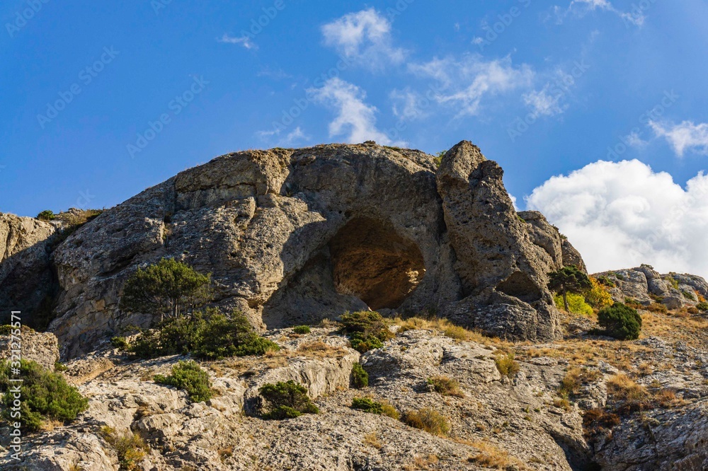 Cape Alchak on southern coast of Crimea on  outskirts of resort town of Sudak. Fabulous view of big mountain with Aeolian harp grotto on Alchak-Kaya trail. Close-up of huge stones and natural boulders